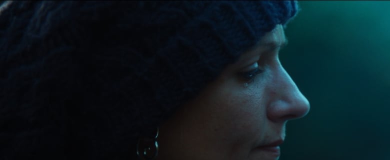 Close up of woman's profile with one tear rolling down her cheek.