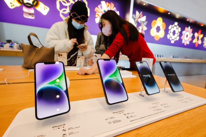 Customers look at the iPhone 14 phone at an Apple store in Beijing, China in November 2022