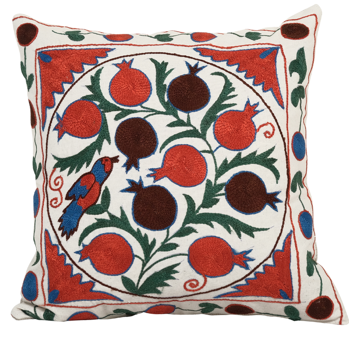 A cushion with a pattern of red berries and a bird 