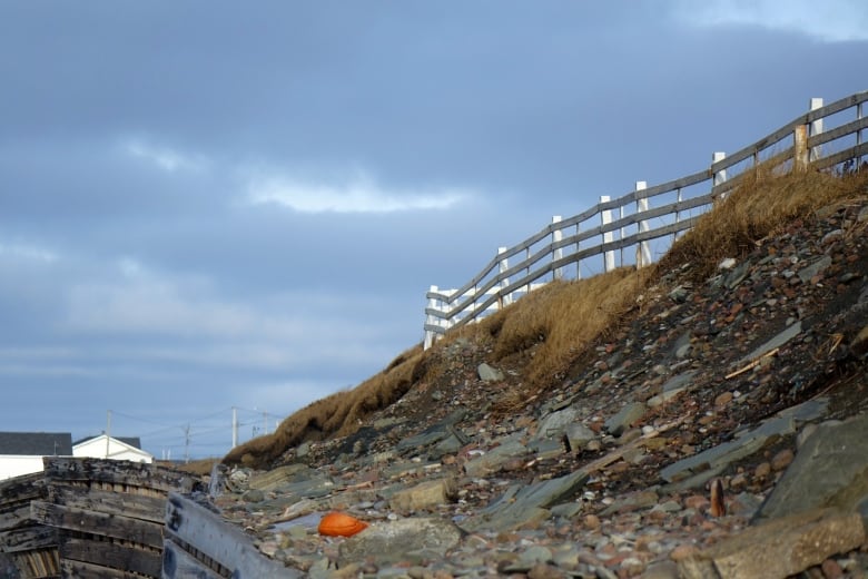 A picket fence on the edge of a cliff.