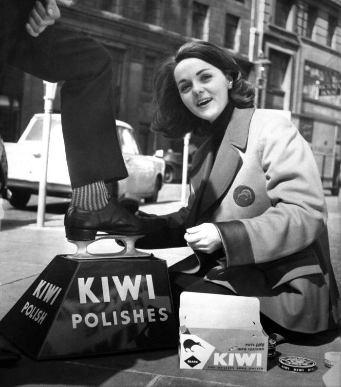 A female shoe shine cleaning a man’s shoes in London in 1963