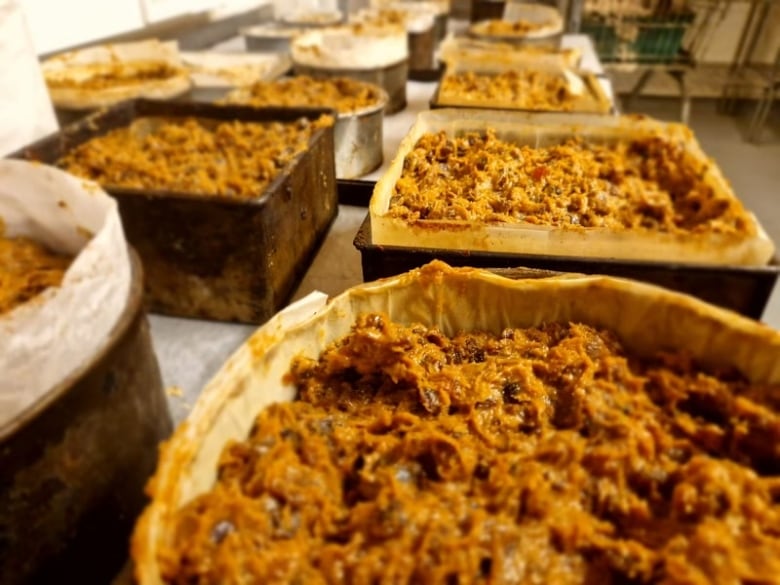 A close-up of a row of freshly baked cakes, still sitting in their pans. 