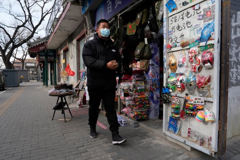 A man walks past a convenience store.