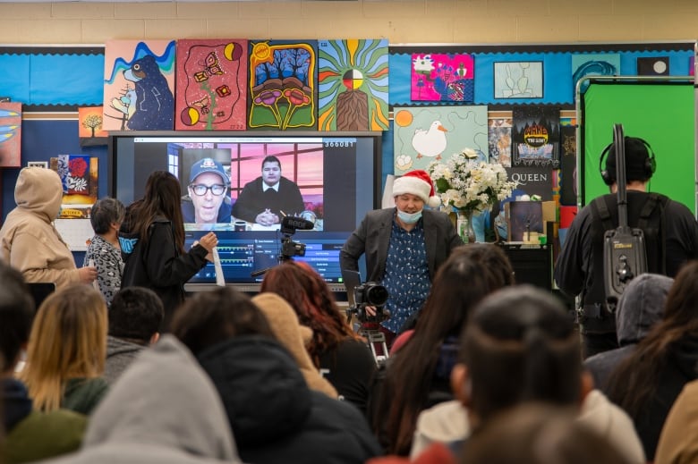 Students watch an interview happening over Zoom. 