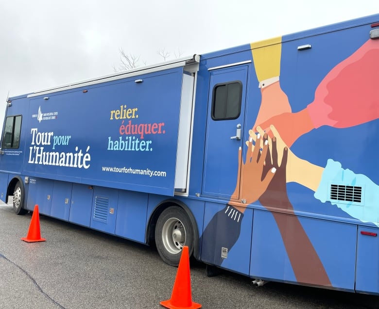 A large bus with 'Tour for Humanity' painted on its side.