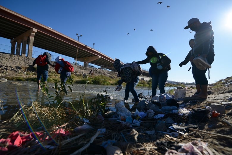 Migrants walk through water to reach the U.S. border in Ciudad Juarez, Mexico.