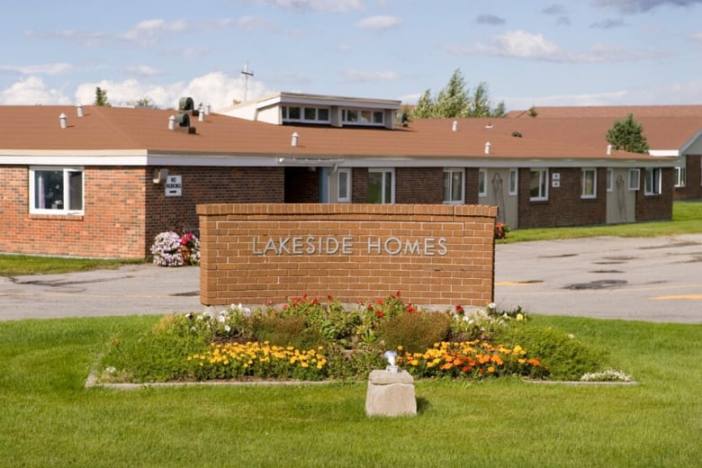 A sign on a brick wall says "Lakeside Homes," and a brick personal care home sits in the background.