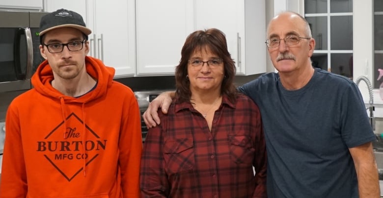 Portait of Josh Savery standing beside his parents, Peggy and Lloyd. 