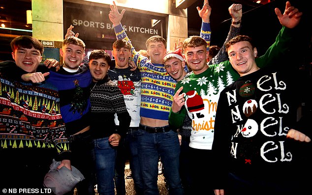 A group head out in Leeds wearing a colourful variety of Christmas jumpers this evening