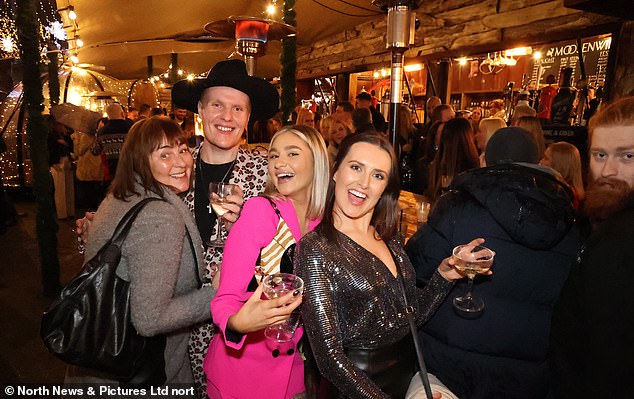 Revellers enjoy themselves in an outdoor bar in Newcastle tonight as they shelter from the rain