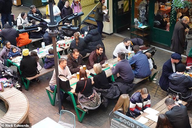 People enjoy drinks in Soho this evening, ahead of the Christmas holiday this weekend