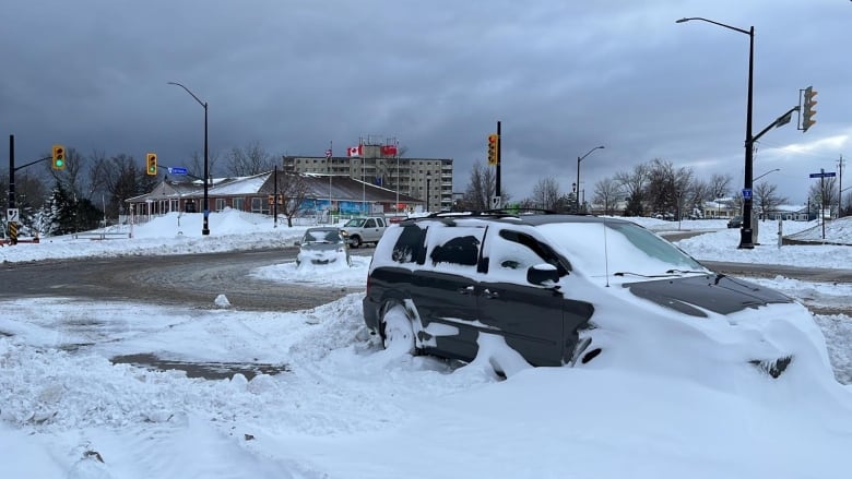 A parked vehicle covered in snow. 