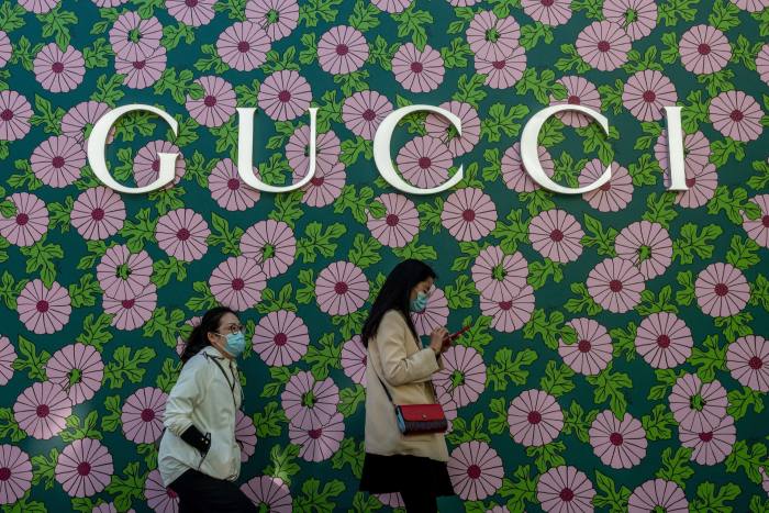 Two women walk past a Gucci  shop in Beijing