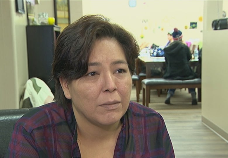 A woman with short dark hair listens to a question. 