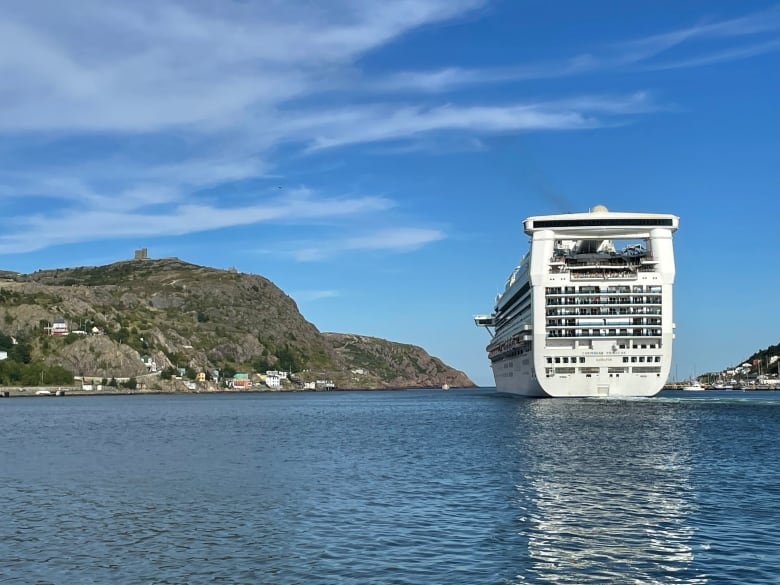 A cruise ship leaves a harbor. 