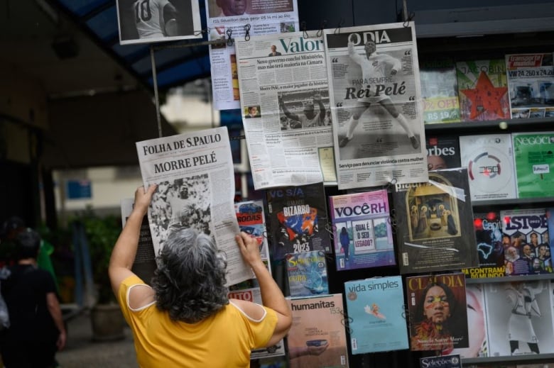 A woman looks at newspapers.