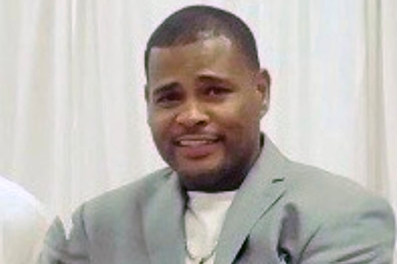 Close up of a smiling man with balck hair, wearing a green blazer