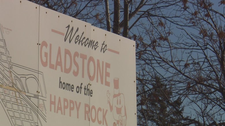 A sign that says. "Welcome to Gladstone, home of Happy Rock.