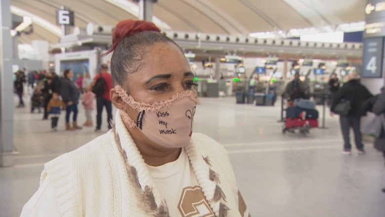 A woman with a mask is pictured at an airport.