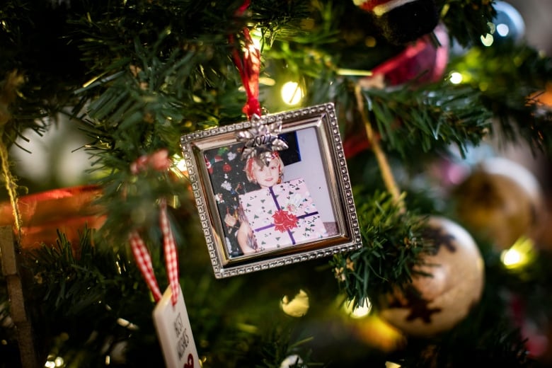 Dennis Cooper is pictured holding a picture of his child who was shot and killed by police in November in North Vancouver, British Columbia on Tuesday December 13, 2022. 