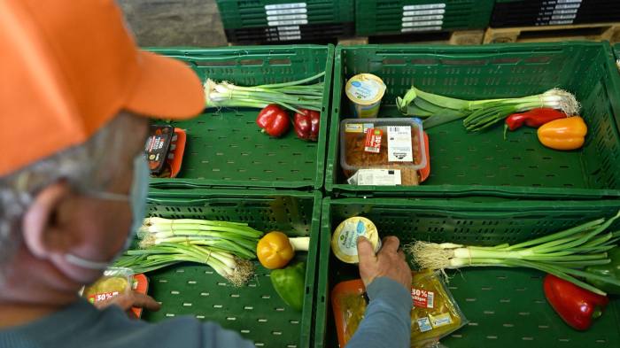 A volunteer sorts food into crates in Bochum, Germany