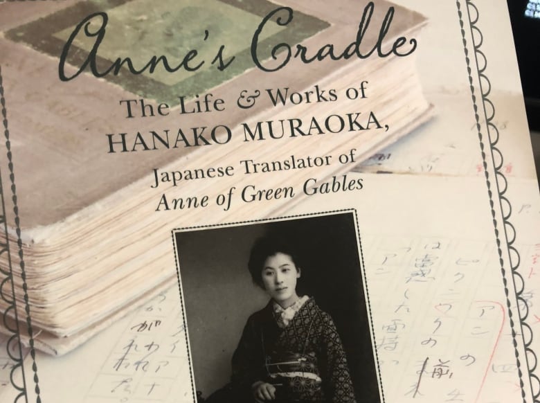 A book cover showing a black-and-white photo of a womn wearing a kimono and an image of a manuscript. 