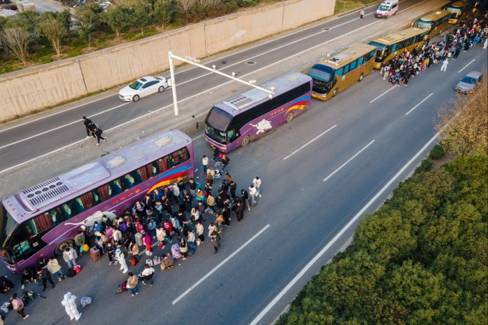 Foxconn staff wait to board shuttle buses in Zhengzhou, Henan, China to their home towns in October 2022