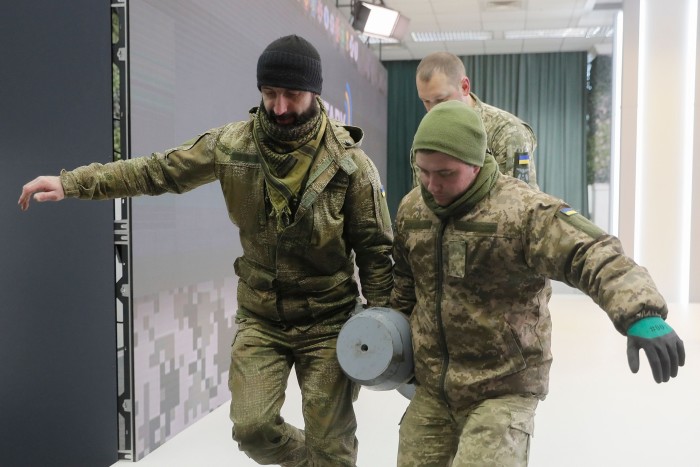 Ukrainian servicemen carry the filler of the warhead part of what is described as a Russian Kh-55SM missile in Kyiv, Ukraine