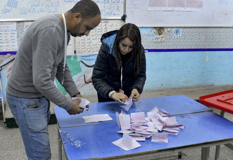 Election workers count and sort ballots.