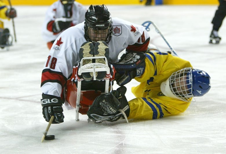 Two male para hockey players collide.