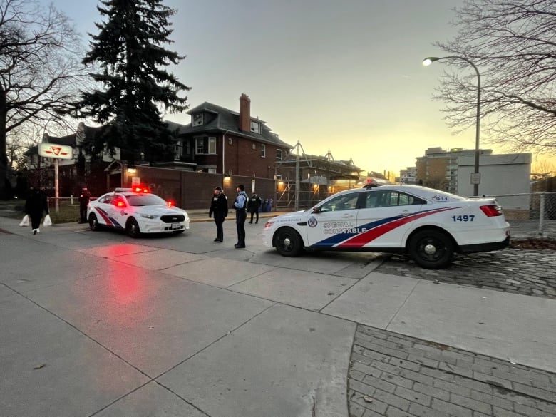 Two police cars block off the entrance to the TTC station.