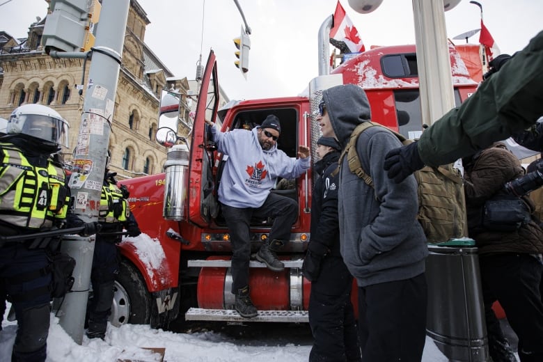 A man is stepping out of a heavy truck