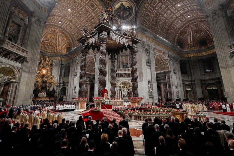 A wide shot of a crowd inside a large church.