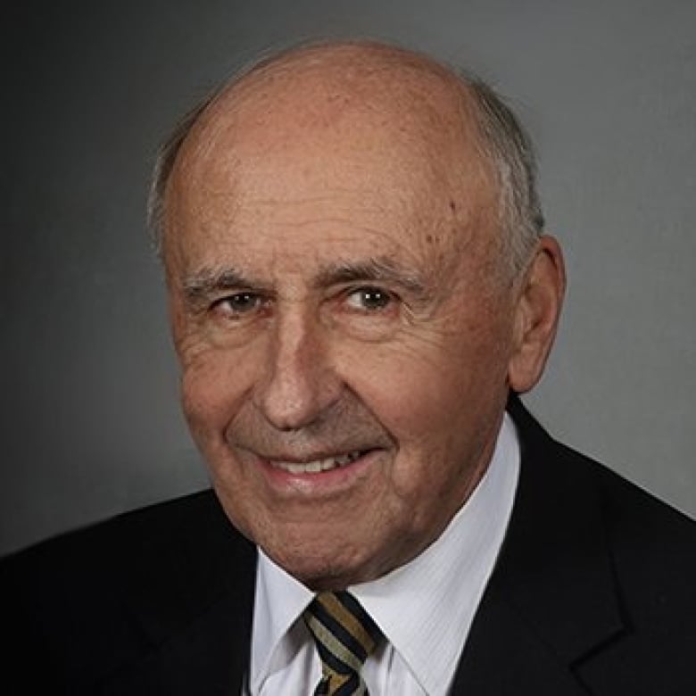 A headshot of a man in a suit.