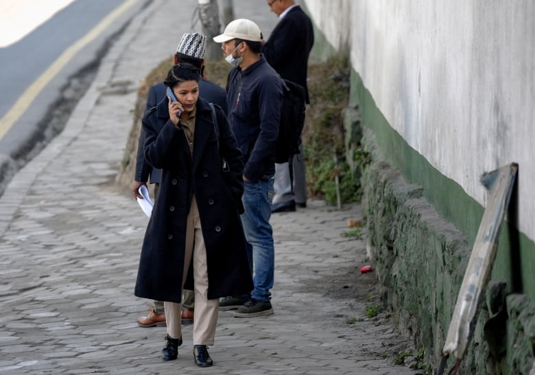 A woman talks on a cellphone while walking.