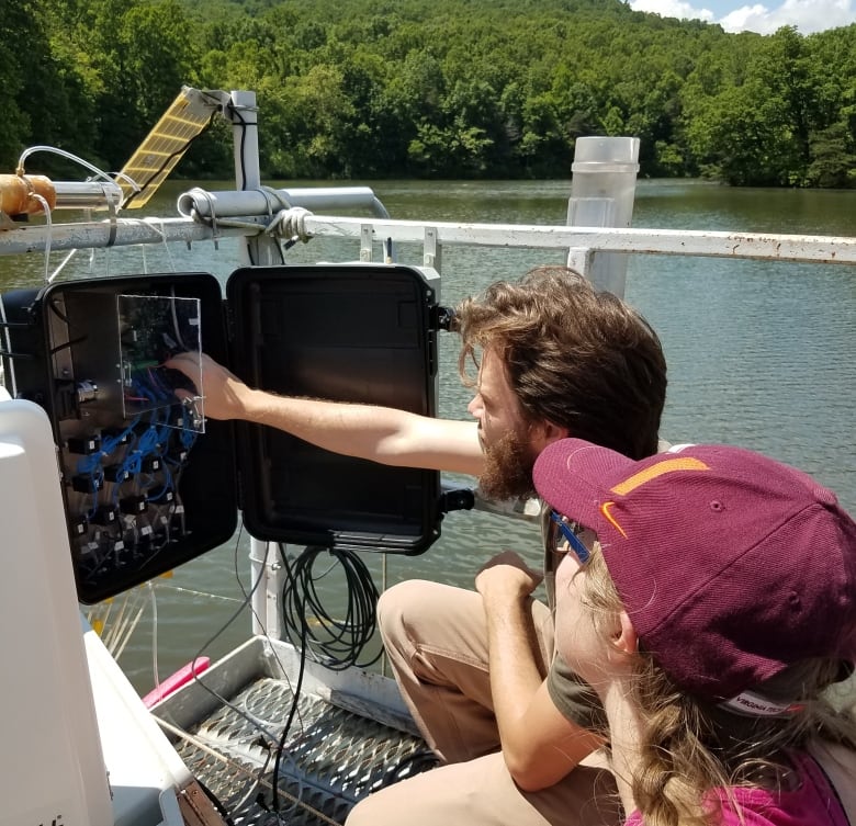 Researchers take measurements on the water.