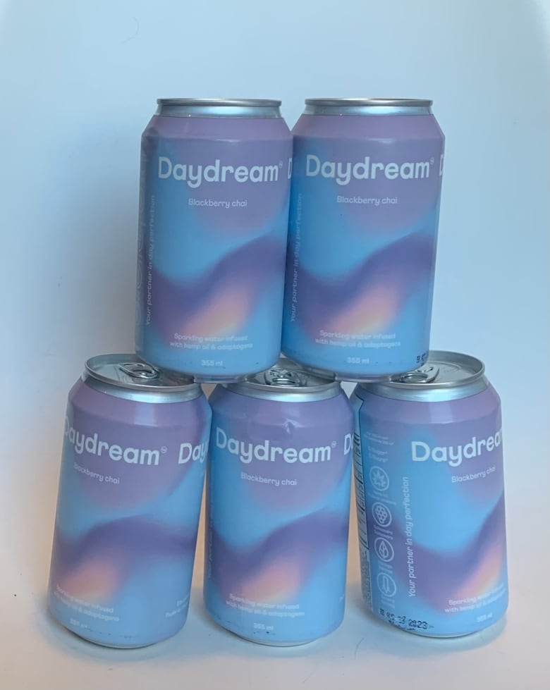 A stack of canned beverages in lavender colours have the name Daydream Blackberry Chai