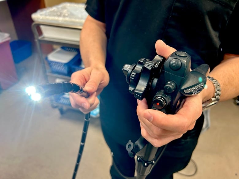 Dr. Ian Bookman, medical director of the Toronto-based Kensington Screening Clinic, holds up the long, black scope used during a colonoscopy. 