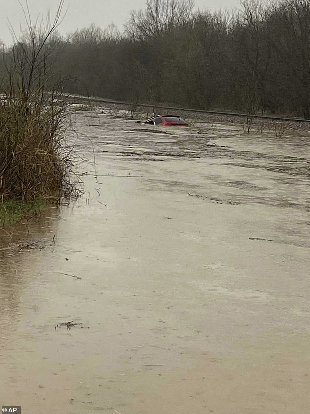 A red SUV is seen submerged in floodwaters on Old Ritchey Road in Granby, Missouri early on Friday.An elderly woman was recued from the car