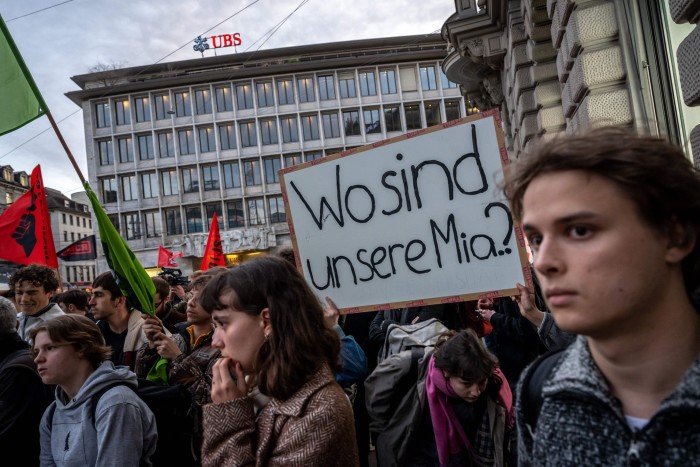 Young demonstrators hold posters outside banks