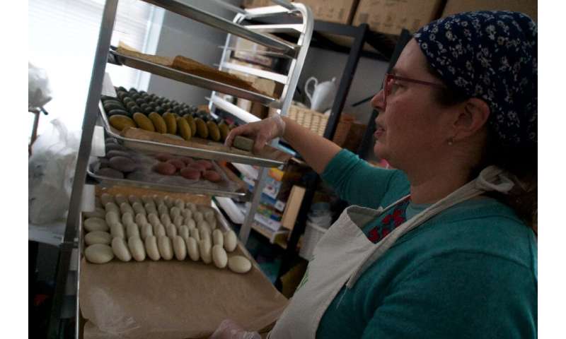 Emoke Gaidosch, chemist and co-owner of the FullFillery, shows personal care products that she makes at the shop in Takoma Park,