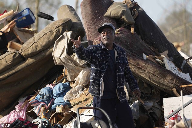 A resident looks through the piles of debris, insulation, and home furnishings to see if anything is salvageable at a mobile home park in Rolling Fork