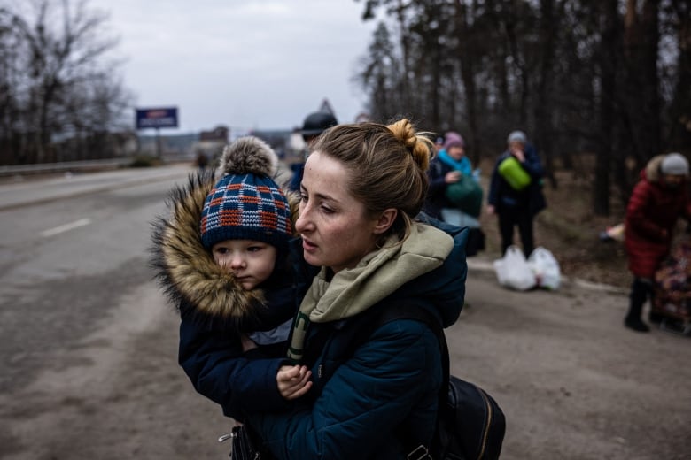 A woman carries her child.