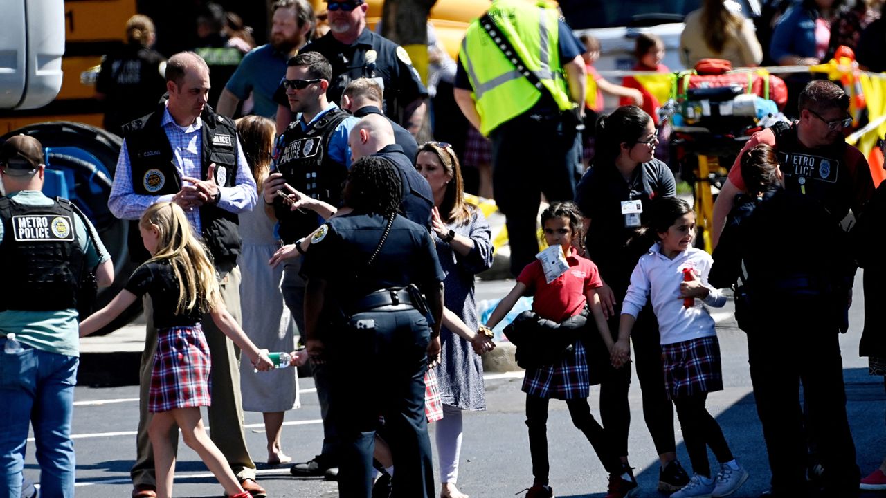 Students from the Covenant School hold hands Monday after getting off a bus to meet their parents at a reunification site after a mass shooting at the school in Nashville.