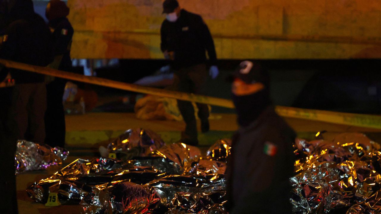 Emergency workers stand near the bodies of the migrants, mostly from Venezuela, who died in the fire.