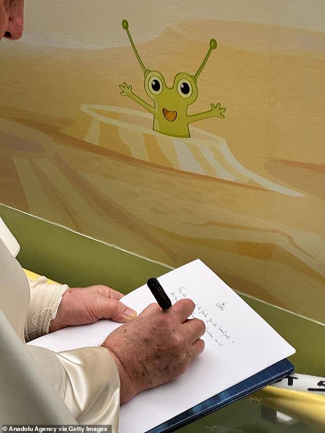 The Pontiff has been cleared by doctors to be discharged from the Gemeli Hospital in Rome on Saturday. Pictured: Pope Francis writes on a visitor book