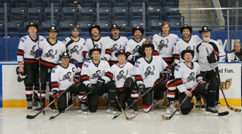 A team of hockey players standing in rows on the ice.