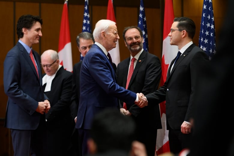 U.S. President Joe Biden shakes hands with Conservative Party of Canada Leader Pierre Poilievre, as Prime Minister Justin Trudeau looks on.