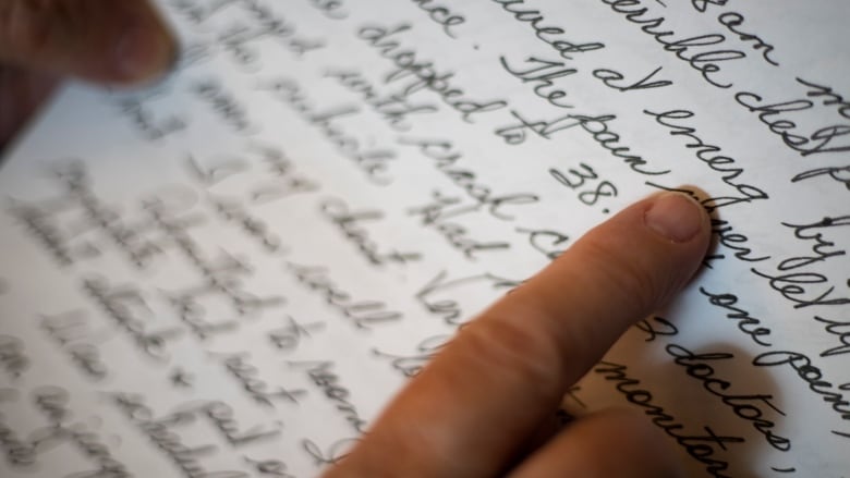 Close-up shot of a woman's finger on a handwritten letter.