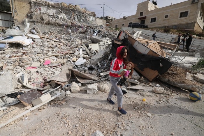 A Palestinian girl picks up her doll from the debris of the house of Rateb Hatab Shukairat, after it was demolished by Israeli bulldozers, in the East Jerusalem neighbourhood of Jabal Mukaber